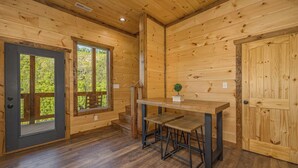 A wooden cabin interior with a dining area, a door, and a window. - *Gorgeous 3BD Cabin w/ VIEWS! Hot Tub + Games!* (Sevierville)