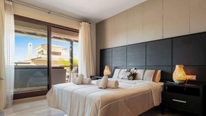 A modern bedroom with a large bed, a dark headboard, and a balcony with curtains. - Apt with pool Marbella by Costarentals - Ref M51 (Marbella)
