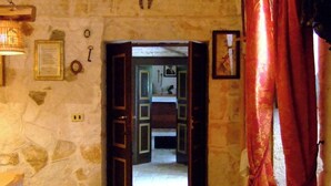 Una habitación con paredes de piedra y una puerta de madera que da a otro espacio.