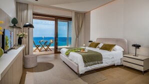 A modern bedroom with a large bed, a desk, and a view of the ocean. - Villa Mulberry 10, Emma Villas (Sciacca)