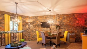 A cozy dining area with a stone wall, a wooden dining table, and chairs.