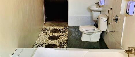 Un baño con bañera, inodoro y ducha.