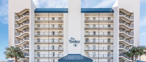 A multi-story hotel with a central entrance, balconies on each floor, and a sign reading "The Breakers".