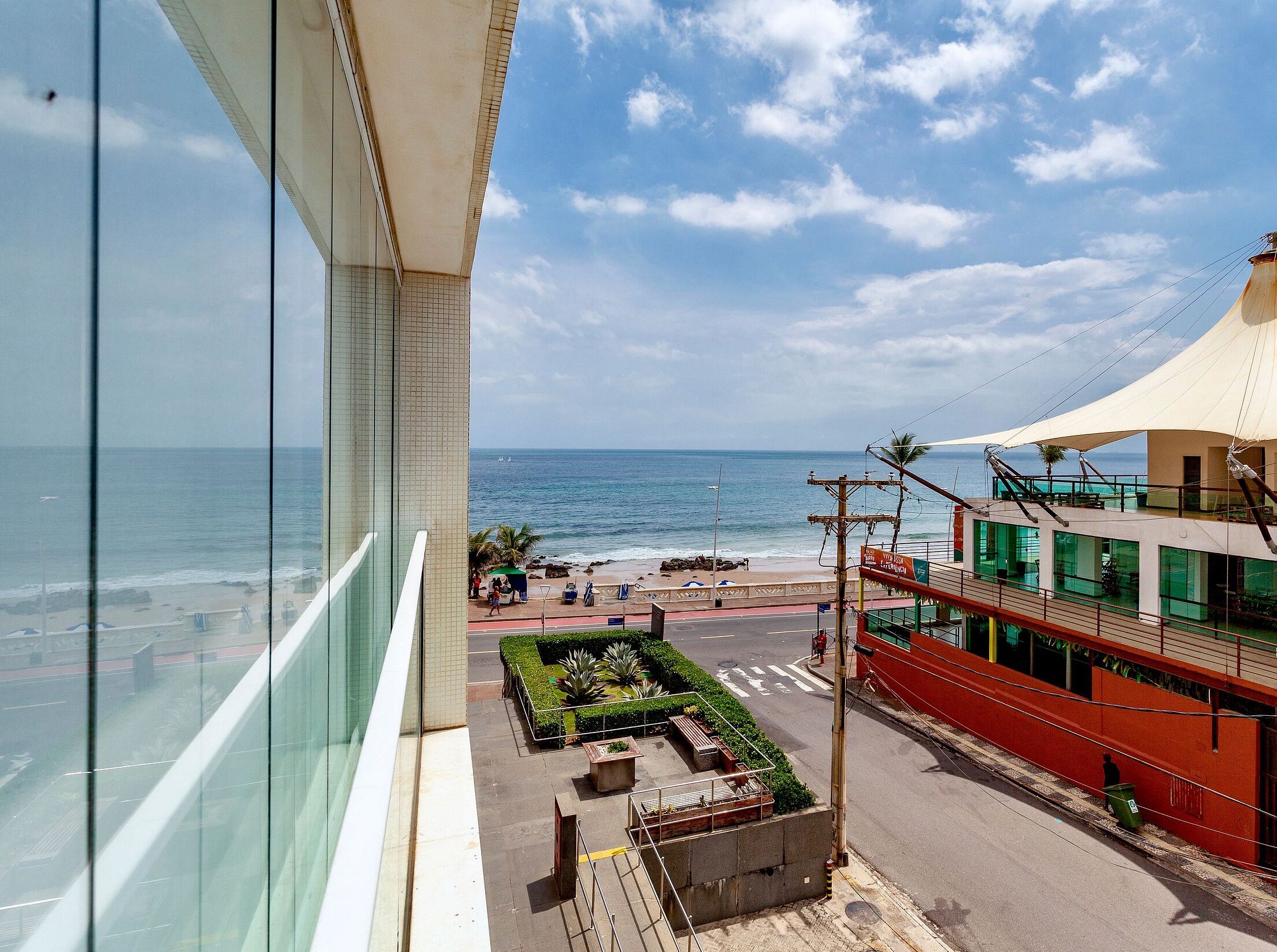 A view from a high-rise building overlooking a beach with a clear sky.