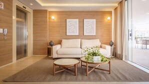 A modern living room with a sofa, two side tables, and a coffee table.