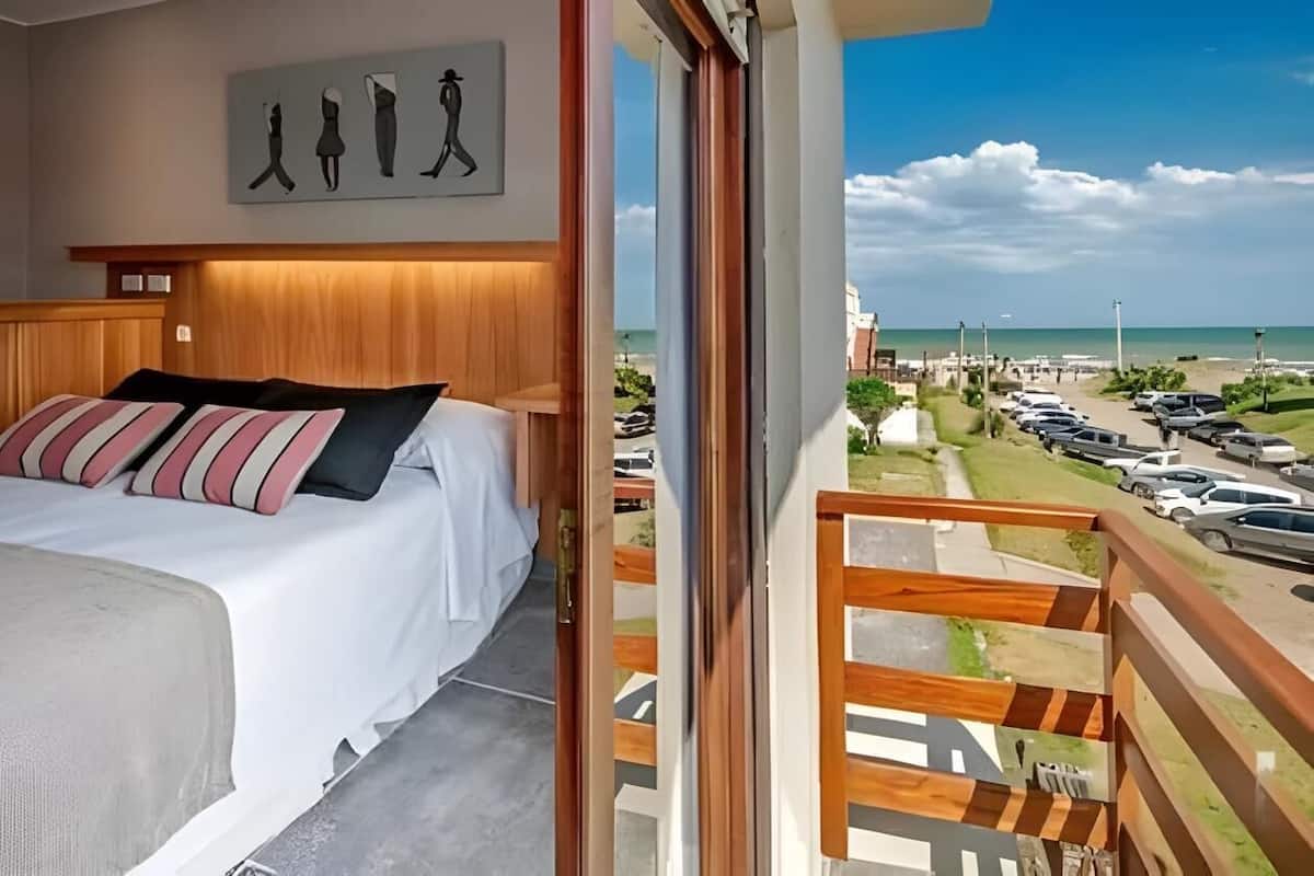 Un dormitorio con una cama, cabecero de madera y un cuadro de figuras.