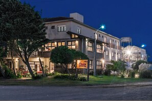 A two-story building with a sign that reads "Dina's." - Romina Art Hotel (Villa Gesell)