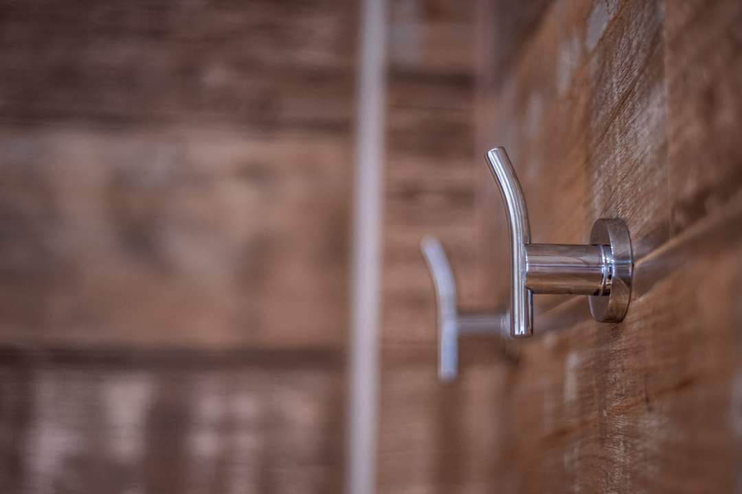 Een metalen deurklink op een houten deur.