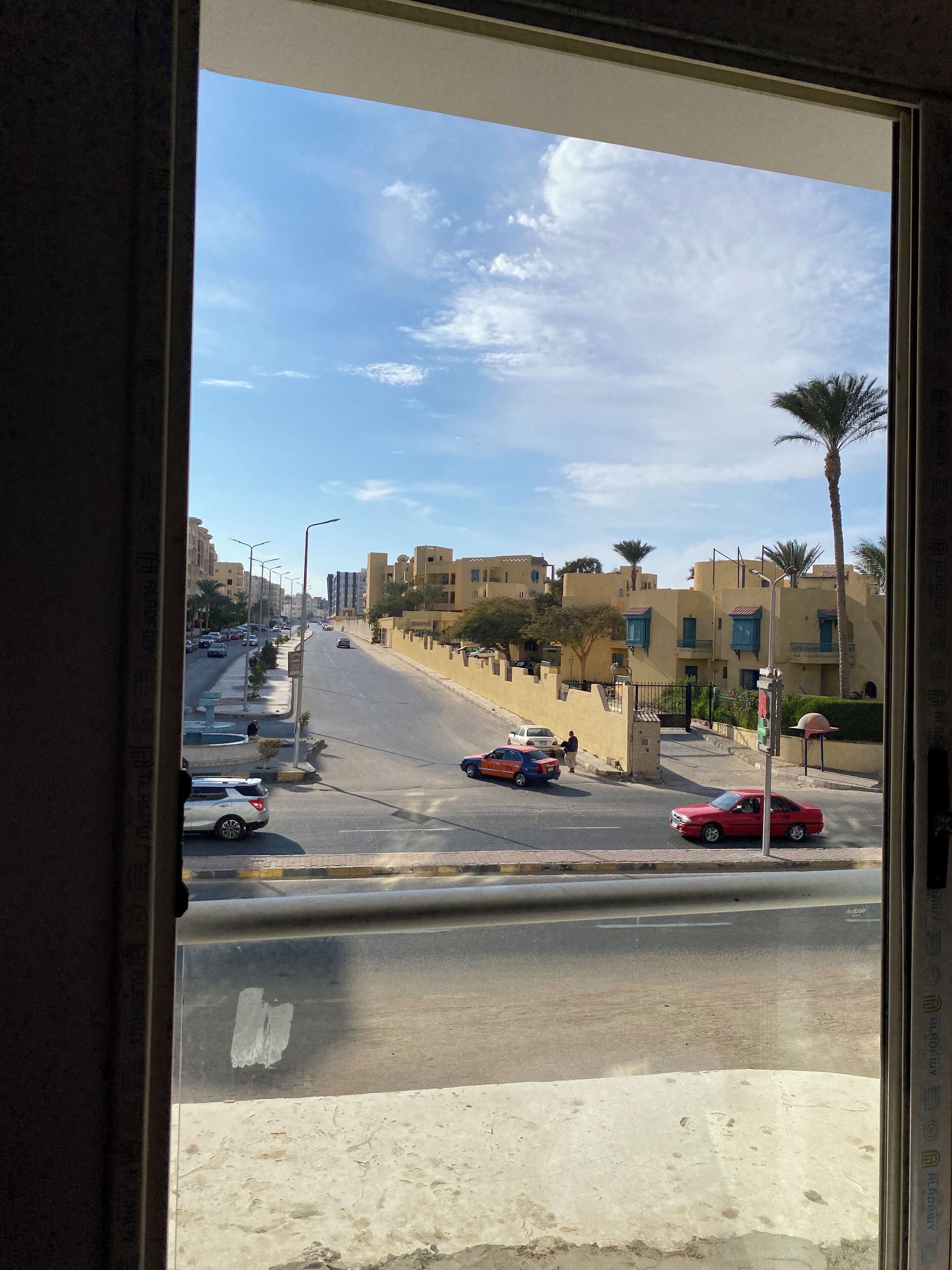 A street view with buildings, cars, and a clear sky.