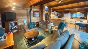 A cozy log cabin interior with a living room, dining area, and kitchen. - Picturesque Family-Friendly Beach Home! Sunrises @ Sandy Point (Ferndale)