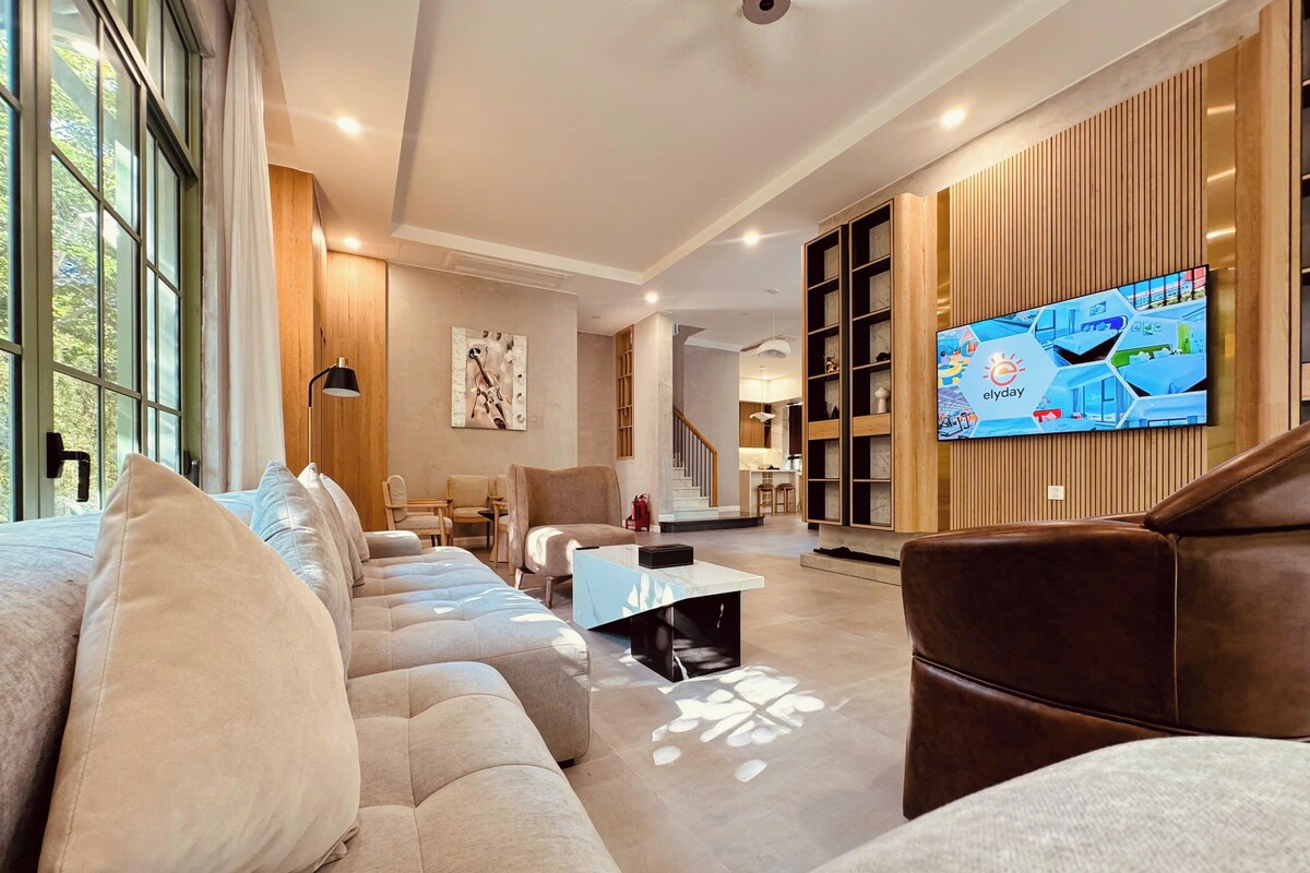 A modern living room with a sofa, coffee table, and a TV mounted on the wall.