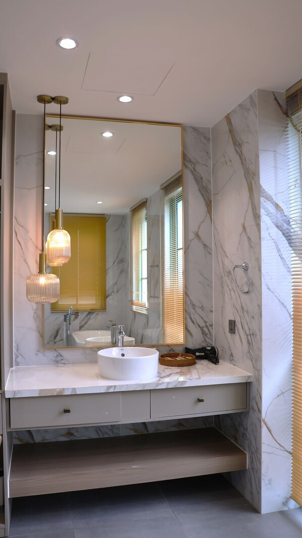 A modern bathroom with a large mirror, two pendant lights, a white sink, and a marble wall. - Elyday Villa - Bai Khem Beach, Phu Quoc (Phu Quoc)