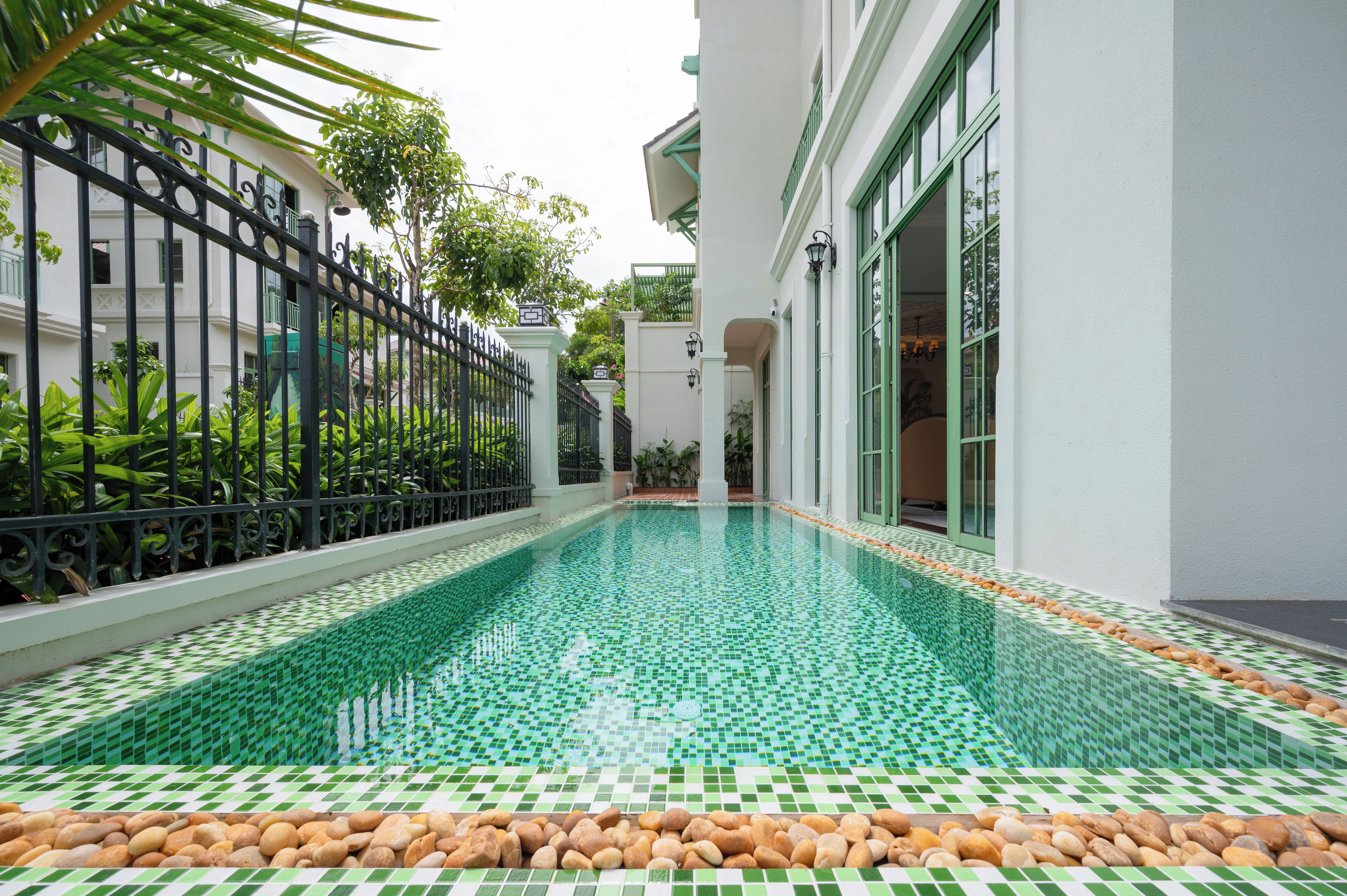 A swimming pool with a tiled floor and a surrounding fence.
