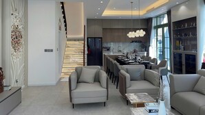 A modern living room with a dining area, a kitchen, and a staircase. - Elyday Villa - Bai Khem Beach, Phu Quoc (Phu Quoc)