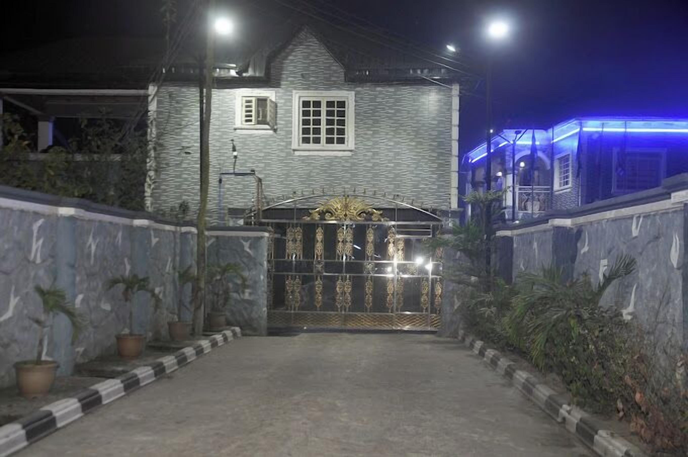 A gated entrance to a building with a stone facade and a metal gate.