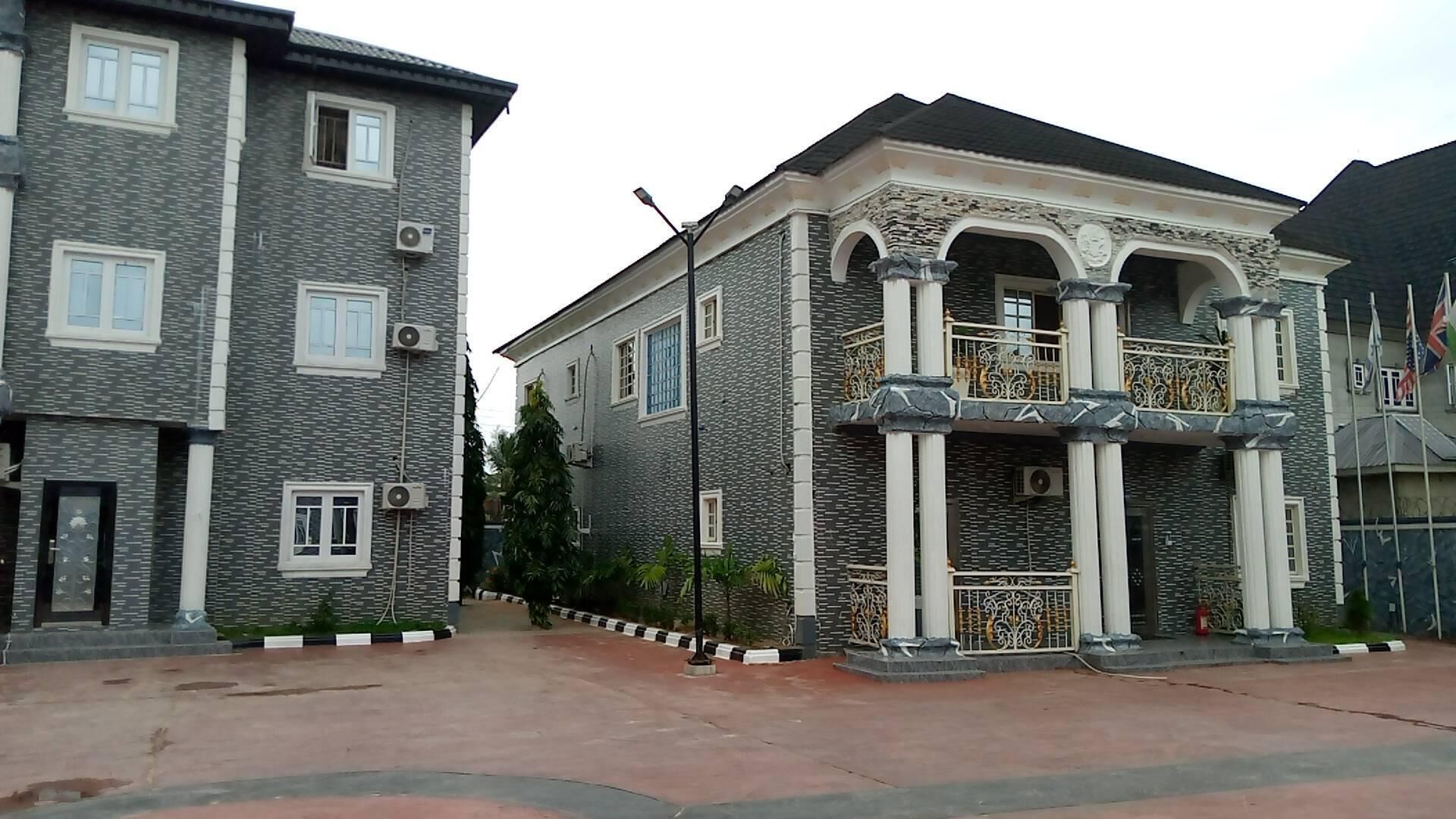 A two-story building with a stone facade, large windows, and decorative columns.