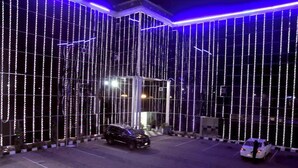 Eine Gebäudefassade mit vertikalen Lichterketten und einem Glastüransatz.