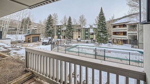 A residential area with a snow-covered ground, a fenced outdoor area, and several multi-story buildings.