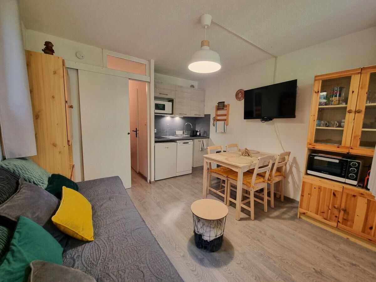 A compact living space with a sofa, dining table, and kitchen area.