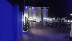 Ein Gebäude bei Nacht mit einem befestigten Eingang, beleuchtet von blau und weißem Licht.