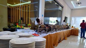 Un buffet avec plusieurs points de service et des piles d’assiettes.