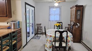 A compact kitchen with a dining area, a ceiling fan, and a wooden cabinet. - Family-Friendly Home in Davis (Davis)