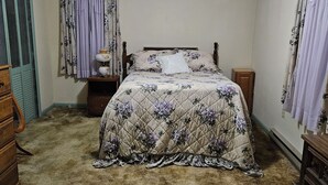 A bedroom with a bed, a ceiling fan, a nightstand, and a dresser. - Family-Friendly Home in Davis (Davis)