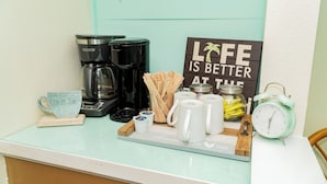 Eine Kaffeestation mit Kaffeemaschine, Tassen und einem Schild mit der Aufschrift 'Life is better at the jar'.