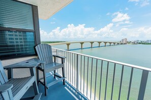 Un balcon donnant sur un pont, avec une chaise et une table.