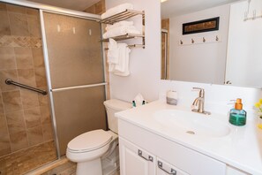 Une salle de bain équipée d’une douche, de toilettes, d’un lavabo et d’un porte-serviettes.