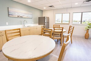 A modern kitchen with a marble countertop, wooden cabinets, and a built-in refrigerator.