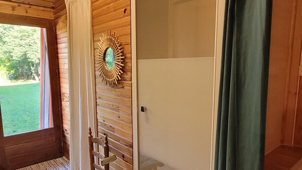 A wooden cabin interior with a shower, a bench, and a view of the outdoors. - Reflet de Bien être : Wooden loft for 3 people with enclosed courtyard. (Marsoulas)