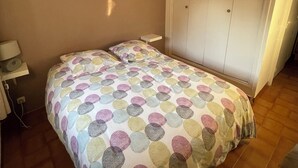 Une chambre à coucher avec un lit, une armoire et une table de chevet.