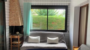 Une petite pièce agréable et confortable, avec un lit, une chaise et une fenêtre donnant sur un jardin.