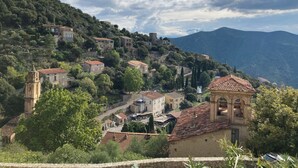 Un village perché sur une colline, avec des bâtiments en pierre, une église et un clocher.