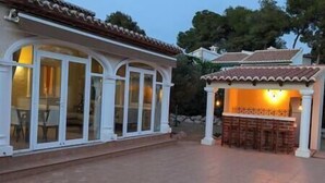 A building with large glass windows and a tiled roof. - Villa Carolina. Costa Nova, Jávea (Xàbia)