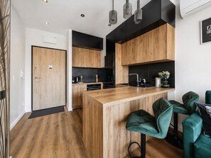 Une cuisine moderne avec des meubles en bois, un îlot central et des tabourets de bar.