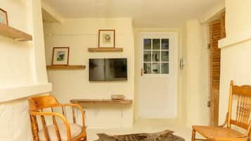 Phòng Suite tiện nghi đơn giản, 1 giường cỡ queen, phòng tắm riêng | Khu phòng khách | Smart TV 28-inch có truyền hình kỹ thuật số