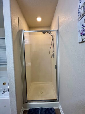 Een douche, een bubbelbad, handdoeken, toiletpapier
