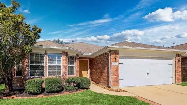 A two-story house with a garage, brick exterior, and a well-maintained lawn. - Cozy Home in Spring,TX with AC /WiFi / Laundry . 20 mins from IAH Airport (Spring)