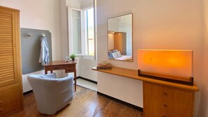 A bedroom with a wooden bed, a bedside table, a chair, a desk, a mirror, and a window. - La Spiaggia (Moneglia)