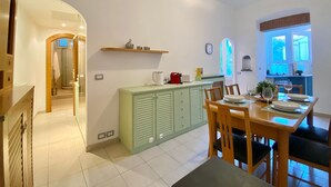 A compact kitchen with a dining area, a small window, and a visible bathroom. - La Spiaggia (Moneglia)