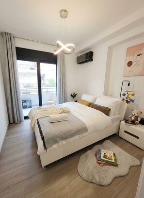 Een moderne slaapkamer met een bed, nachtkastje en uitzicht.