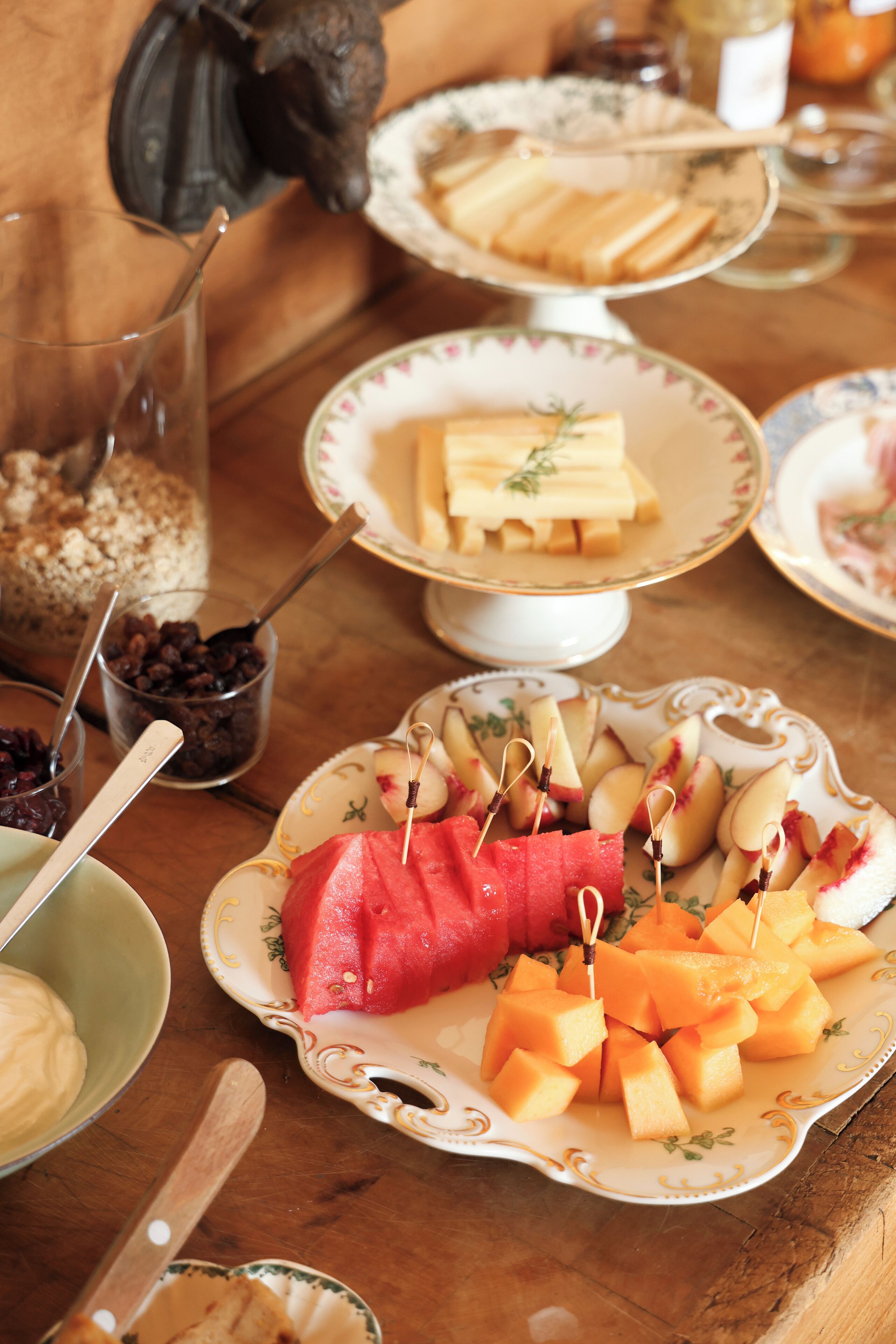 Une table sur laquelle on trouve divers aliments, notamment des pastèques, du fromage et du pain.