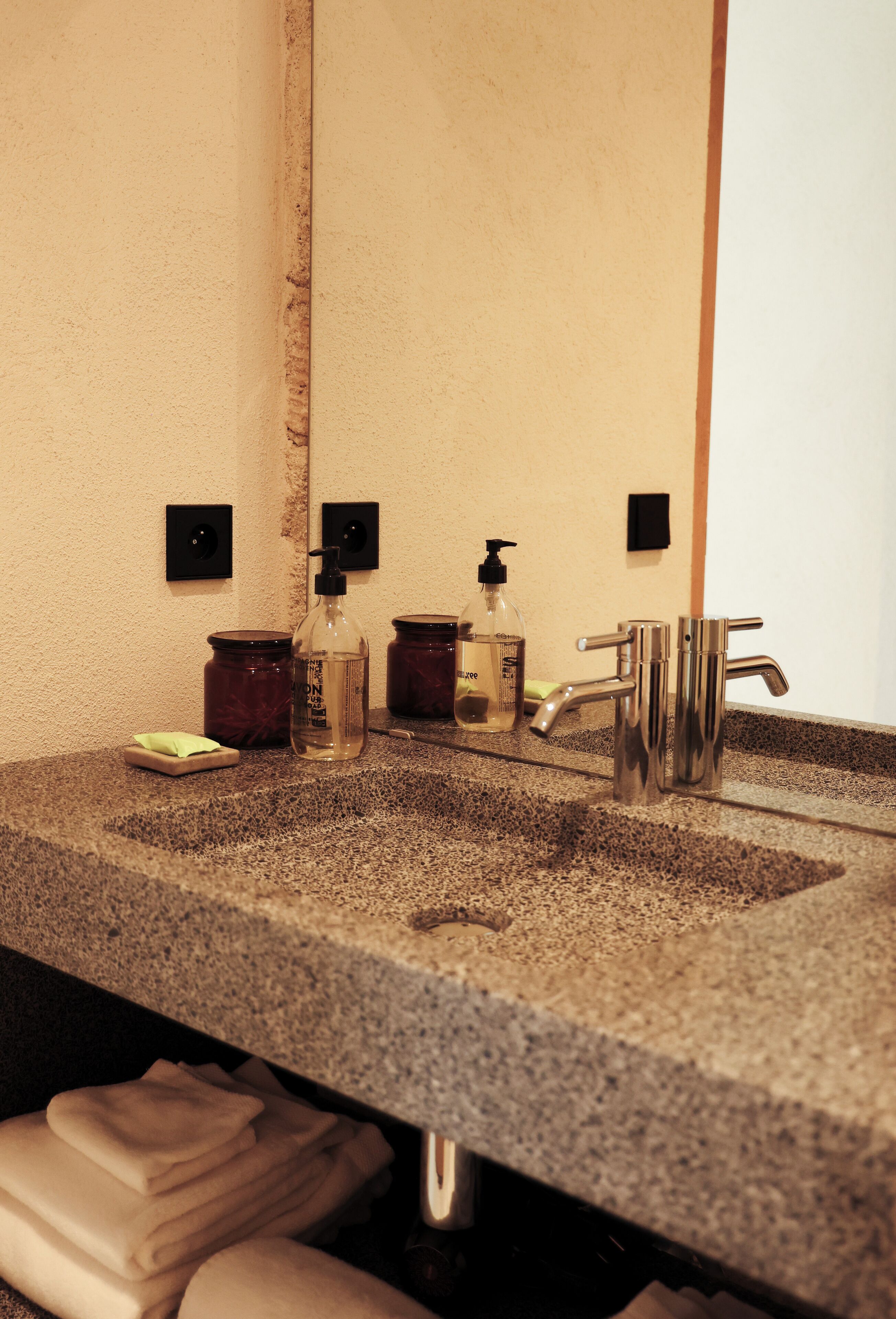 A bathroom sink with a mirror, two soap dispensers, and a faucet.