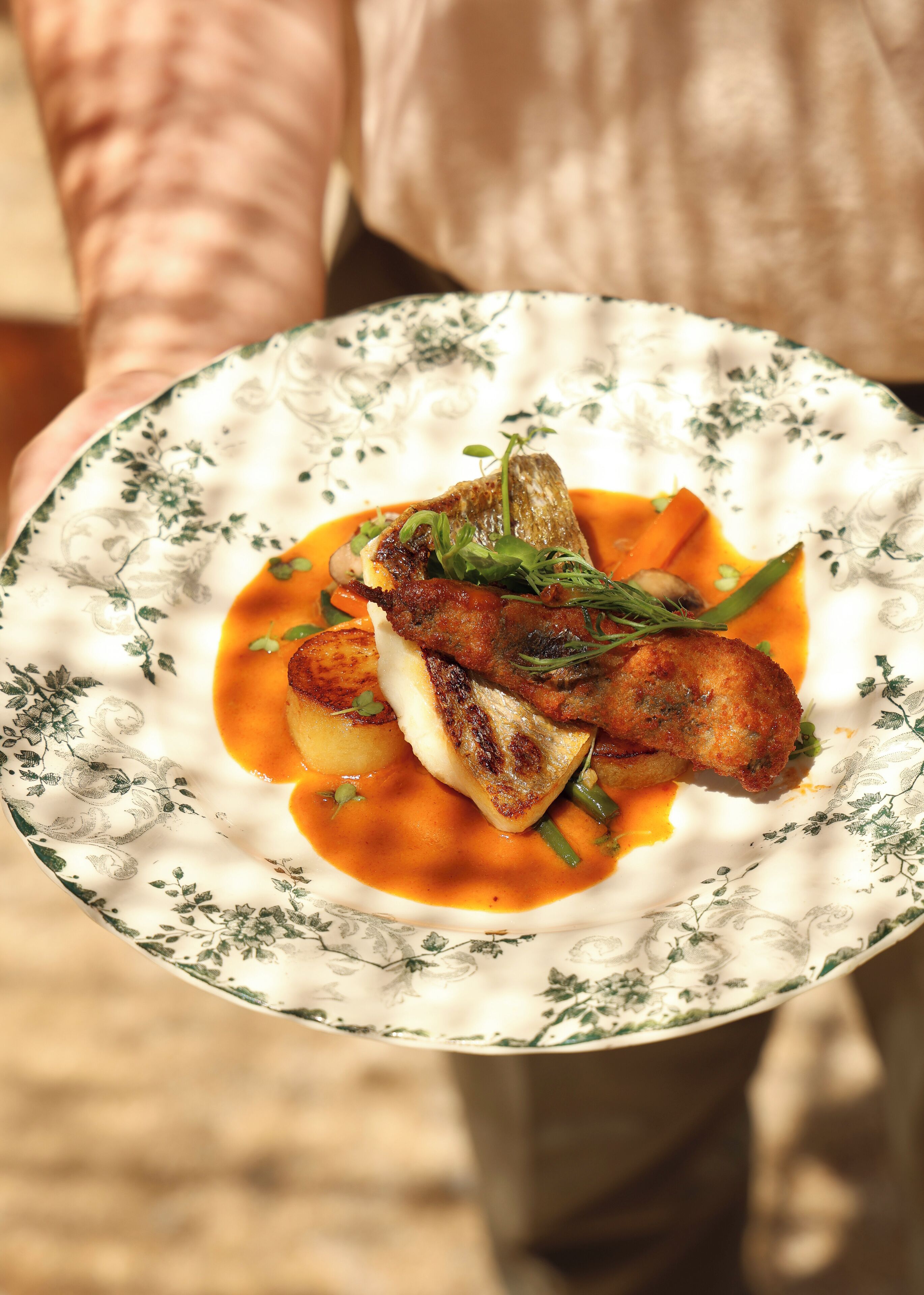 A plate of food with a piece of meat, vegetables, and sauce.