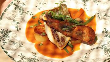 A plate of food with a piece of meat, vegetables, and sauce.