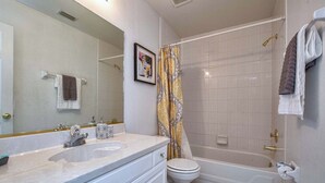 A bathroom with a double sink, toilet, and bathtub. - Rare Disney-Area Waterfront Retreat | Pool & Fountain Views (Kissimmee)