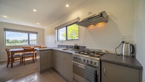 Una cocina moderna con estufa a gas, horno y un ventanal grande.
