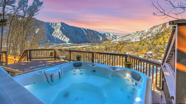 Ein Whirlpool auf einer Terrasse mit Blick auf die Berge.